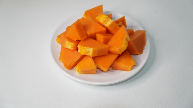 Sliced ripe papaya papaya on a white plate on a white background