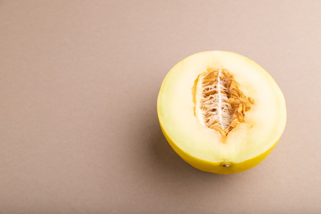 Sliced ripe yellow melon on brown pastel background. Side view, copy space. harvest, women health, 