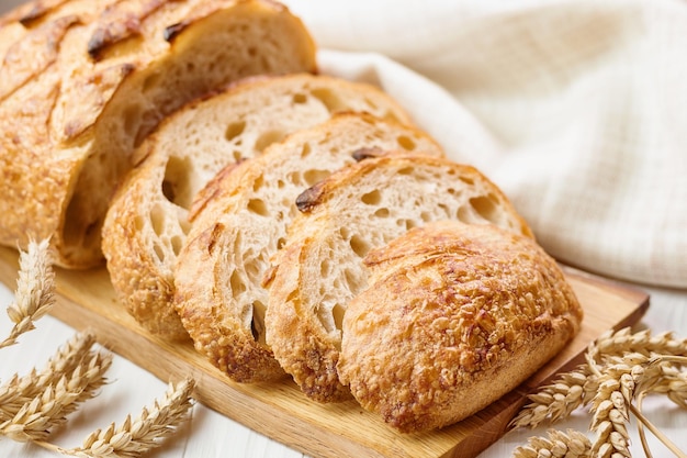 Sliced round wheat bread on board on table selective focus