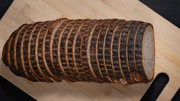 Sliced rye bread on a board on wooden table