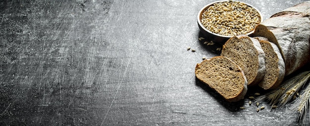 Photo sliced rye bread and grains in bowl