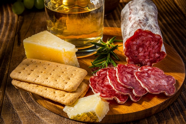 Foto affettato di salame sul piatto di legno con formaggio e vino antipasto italiano