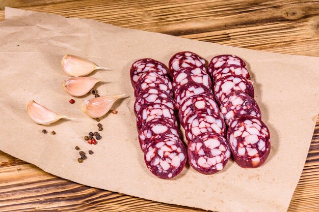 Sliced salami sausage and garlic on a brown wrapping paper