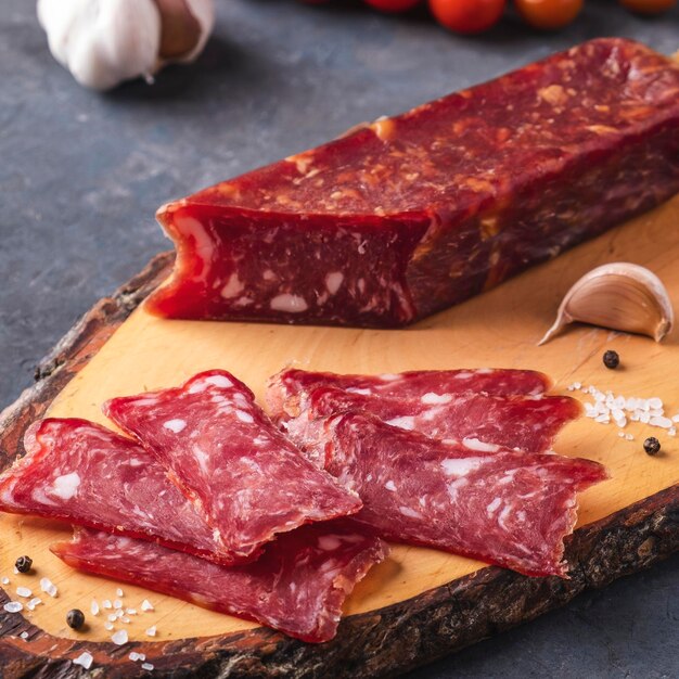 Sliced salami on wooden cutting board Closeup