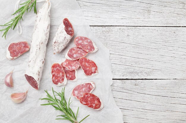 Sliced salami on wooden table