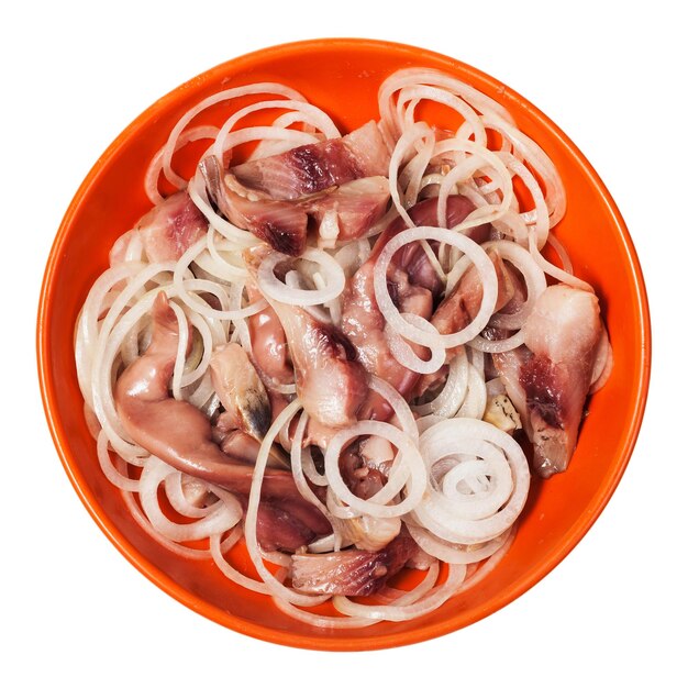 Sliced salted herring with onion in bowl isolated