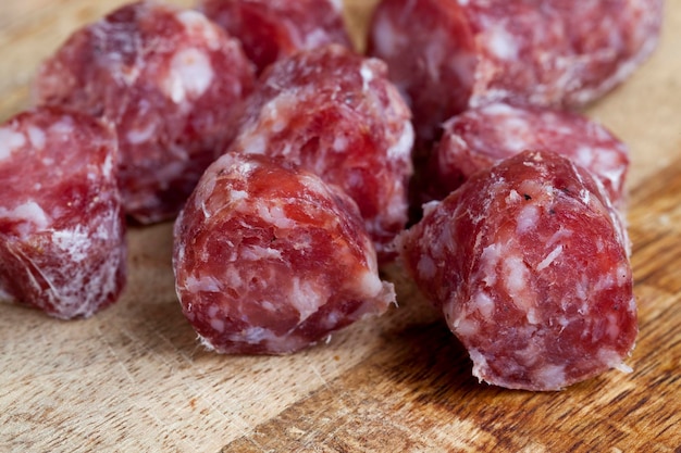 Sliced sausage of dried meat with bacon, pieces of dried meat on a cutting board
