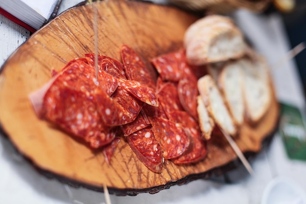 Sliced sausage and meat on wooden table