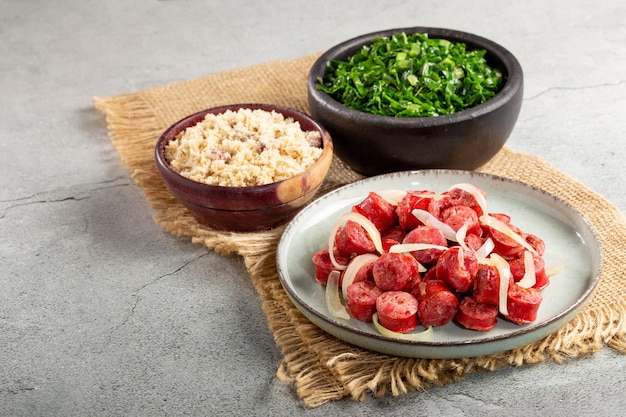 Sliced sausage with onion green cabbage and farofa