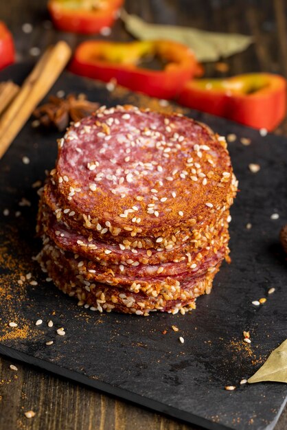 Photo sliced sausage with spices and lots of sesame seeds