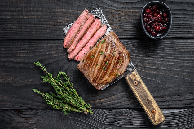 Sliced skirt beef meat steak on a cleaver