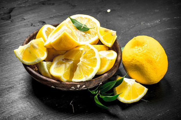 Sliced slices of lemons in a bowl. On the black chalkboard.