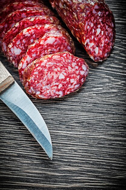 Sliced smoked sausage knife on wooden board