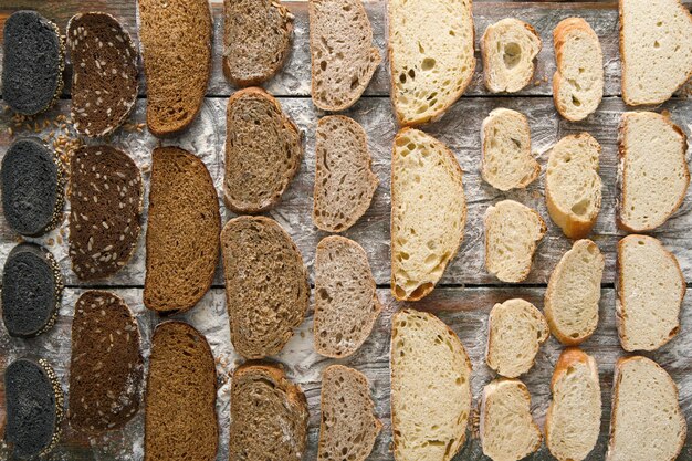 Sliced sorts of bread gradient pattern background. Bakery and grocery concept. Black, rye and white loaves