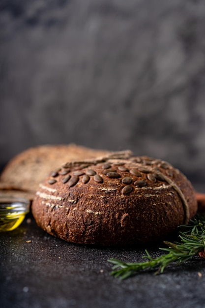 Sliced sourdough bread from whole grain flour and pumpkin seeds on a grid olive oil and black olive