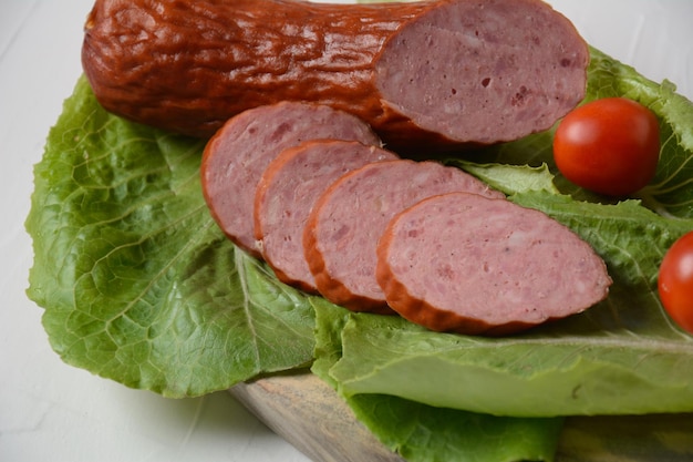 Sliced spicy smoked beef/ pork sausage.With lettuce leaf and cherry tomatoes.