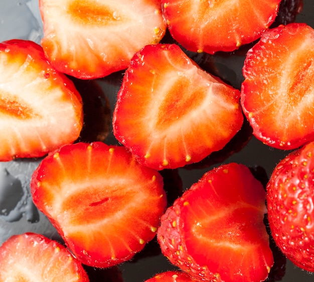 Sliced strawberry during cooking on a wooden cutting board