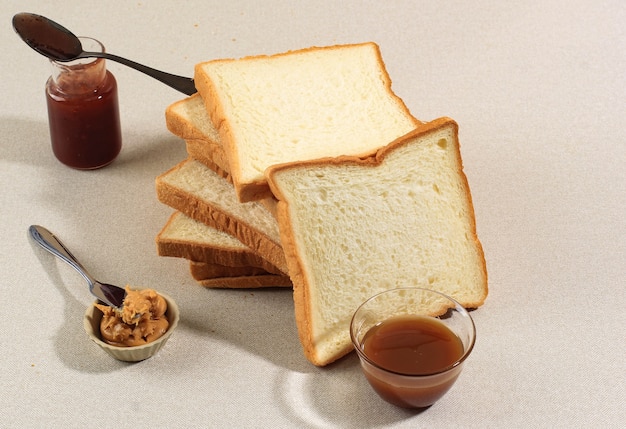 Sliced Toast Loaf White Bread (Shokupan or Roti Tawar) for Breakfast on Clear Background, Served with  Strawberry Jam and Caramel Sauce. Bakery Concept Picture. Copy Space for Text, Recipe