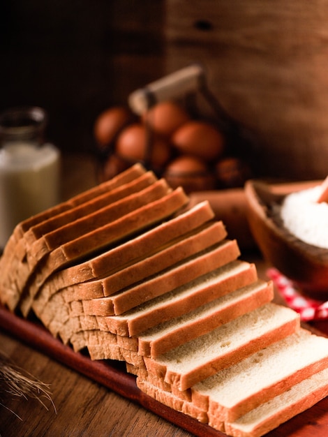 Sliced Toast Loaf White Bread (Shokupan or Roti Tawar) for Breakfast on Wooden Background, Served with Egg and Milk. Bakery Concept Picture