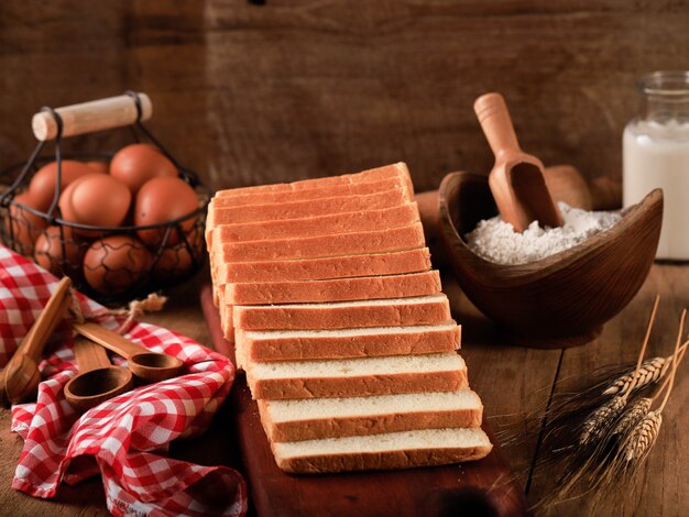 Sliced Toast Loaf White Bread (Shokupan or Roti Tawar) for Breakfast on Wooden Background, Served with Egg and Milk. Bakery Concept Picture