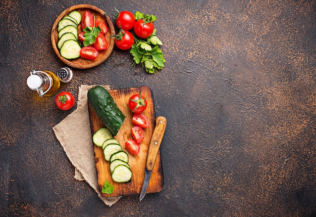 Sliced tomato and cucumber on cutting board