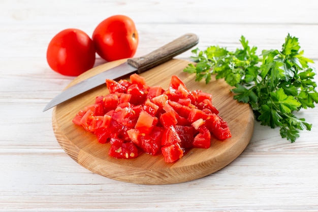 Photo sliced tomato on a cutting board on a wooden table. healthy veggie recipe