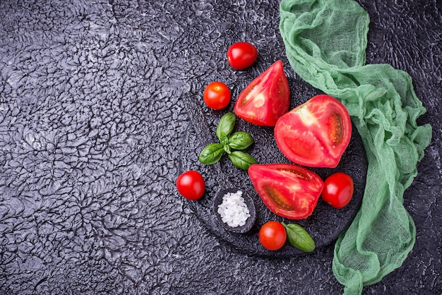 Sliced tomatoes on black background