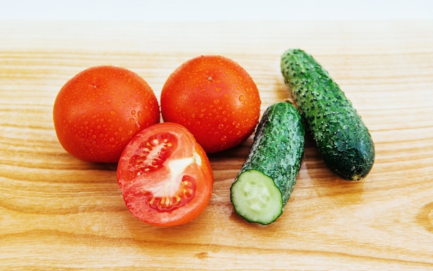 Sliced tomatoes and cucumbers on board