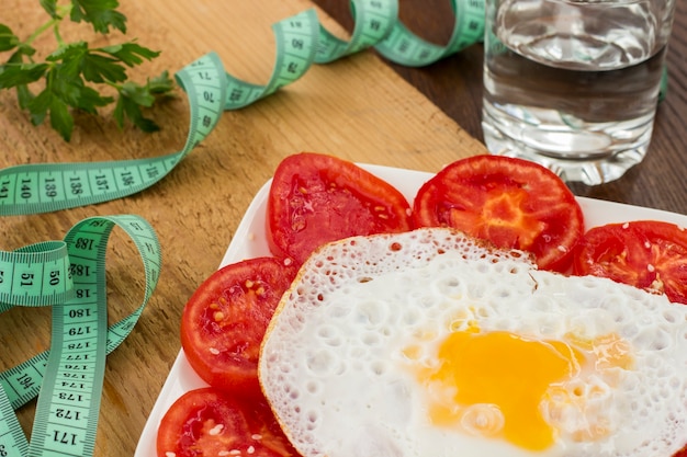 Sliced tomatoes and egg on a white plate