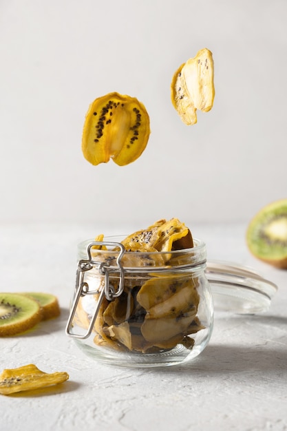 Sliced vegan fruits kiwi chips in glass jar