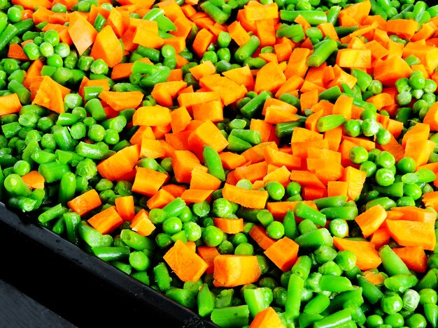 Sliced vegetables before baking on the Pan for baking. Carrots, green peas, green beans. 