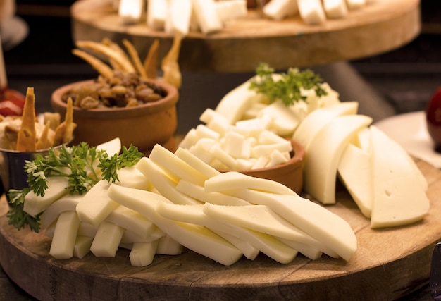 Foto formaggio bianco a fette con verdure su una tavola di legno. foc. selettiva