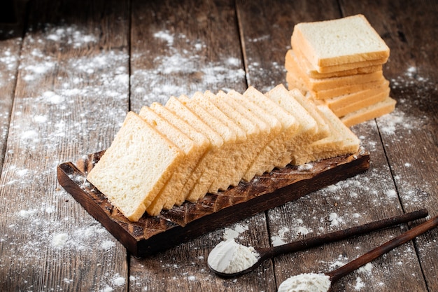 Sliced white sandwich bread on a wooden board