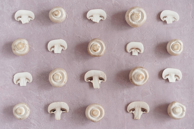 Photo sliced and whole champignons on pink pattern