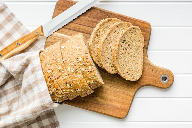 Sliced whole grain bread Tasty wholegrain pastry with seeds on the cutting board Top view