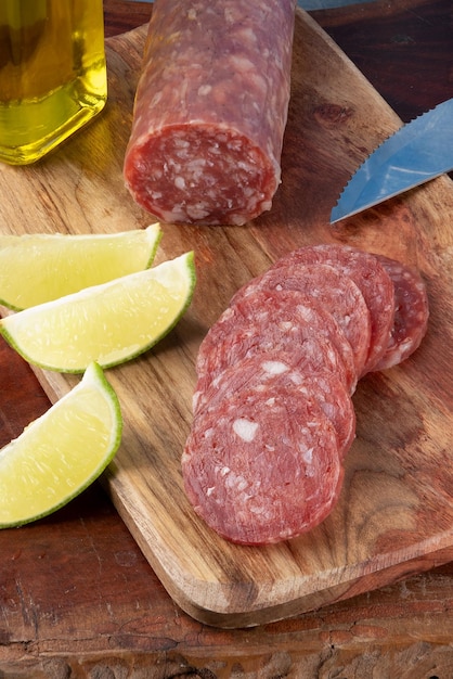 Sliced and whole Italian salami on cutting board