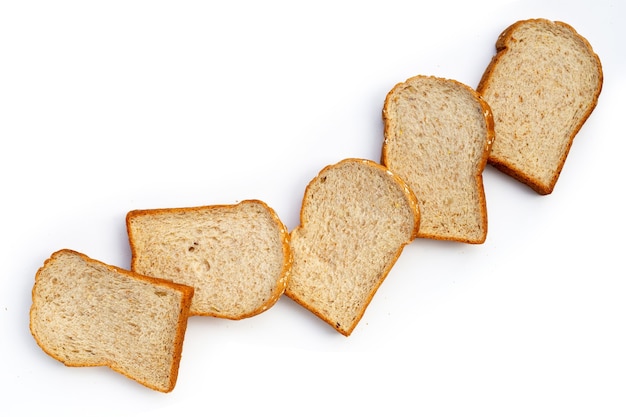 Нарезанный хлеб из цельной пшеницы на белом фоне.