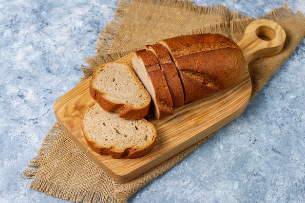 Sliced wholegrain bread on cutting board,top view