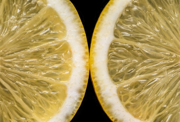 Photo sliced yellow lemon on black background closeup