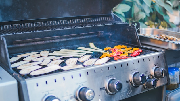 Foto zucchine a fette, grigliate, picnic con barbecue all'aria aperta. barbecue di zucca arrosto sulla griglia metallica. barbecue dietetico vegano. cucinare le verdure alla griglia all'aperto