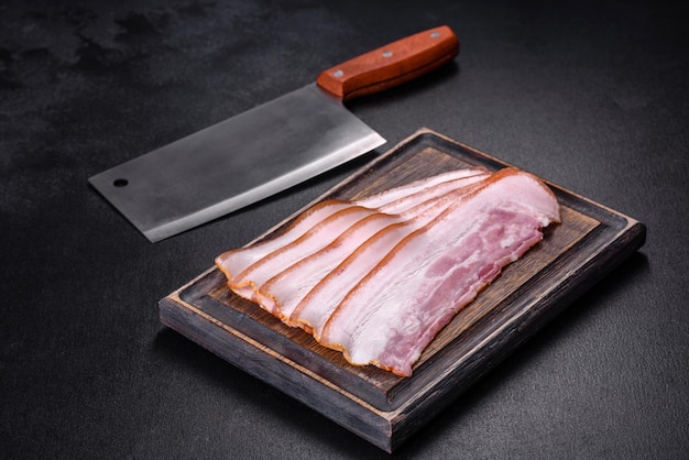 Slices of bacon on a wooden cutting Board Pork meat