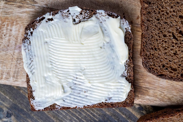 Slices of black sliced bread with butter spread from milk