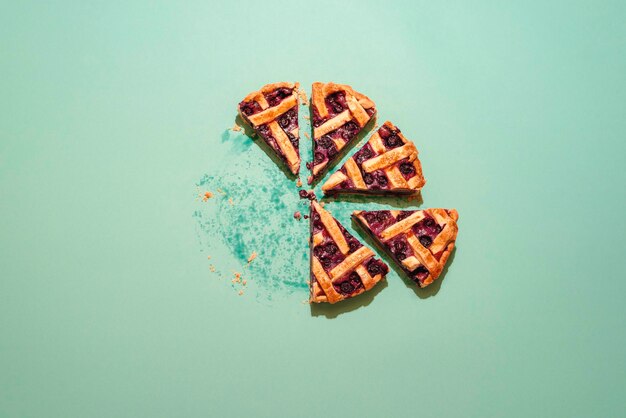 Photo slices of blueberry pie top view on a green background