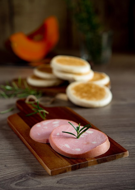 Slices of Bologna PGI mortadella on wooden cutting board