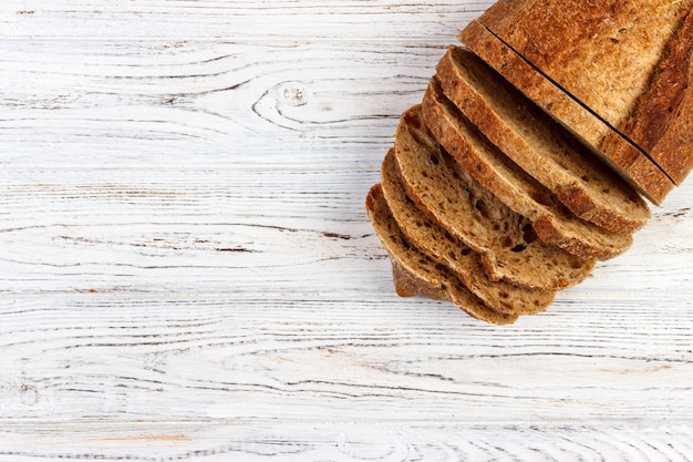 Slices of bread on a wooden tablecloth, top view