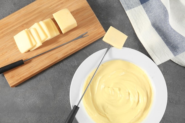 Photo slices of cheese and fondue on table