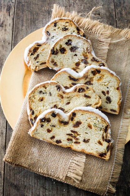 Slices of Christmas stollen Traditional German Christmas dessert on wooden