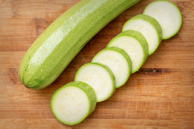 Slices of courgettes on wooden chopping board