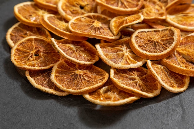 Slices of dehydrated orange on black stone Selective focus