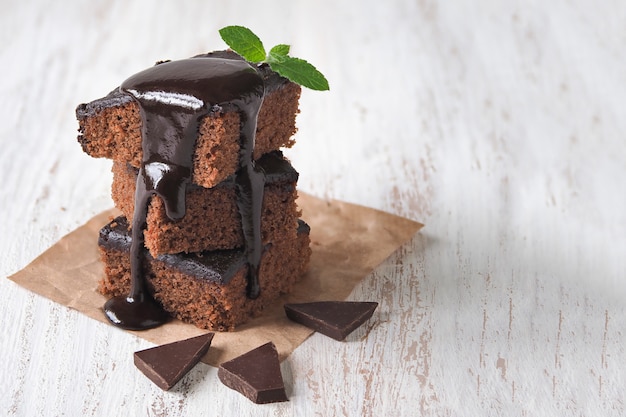 Slices of delicious brownie in a stack and poured with chocolate